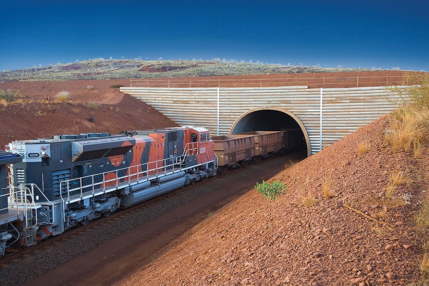 Precast concrete arch solution, TechSpan® by Geoquest pictured at an iron-ore mine, used as a railway tunnel with a train seen entering the precast concrete arch structure