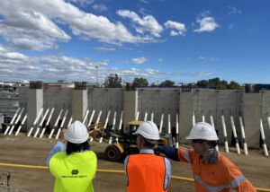 Geoquest engineers in high vis vests survey precast concrete walls at the road infrastrcutrue project, Stephenson Road Extension, at Perth's Mitchell Freeway.