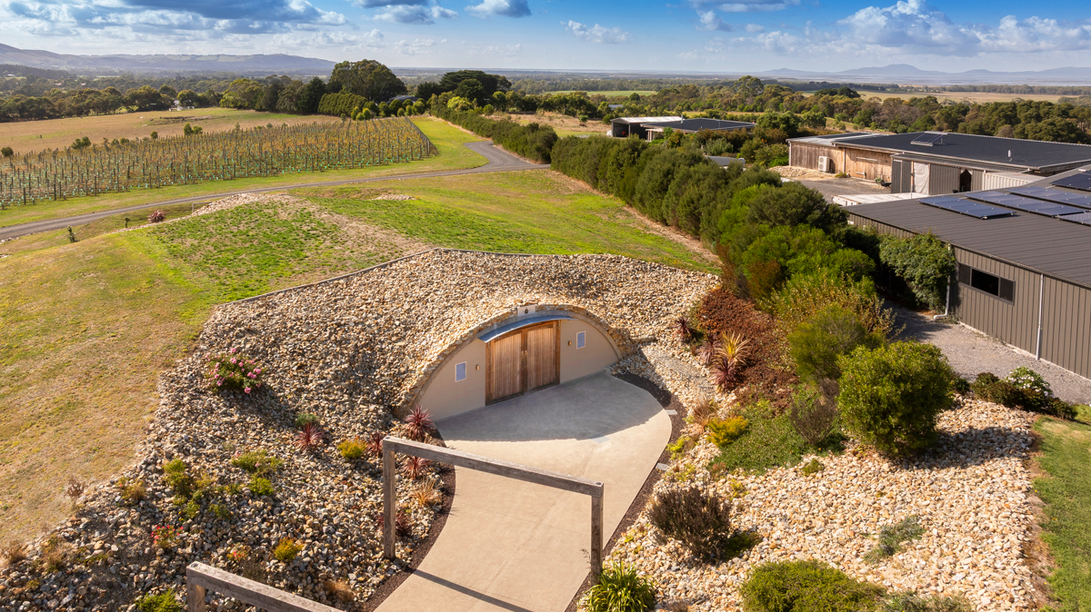 Precast concrete arch in an orchard and vineyards for a winery and cidery in Victoria, Australia. Agricultural architecture