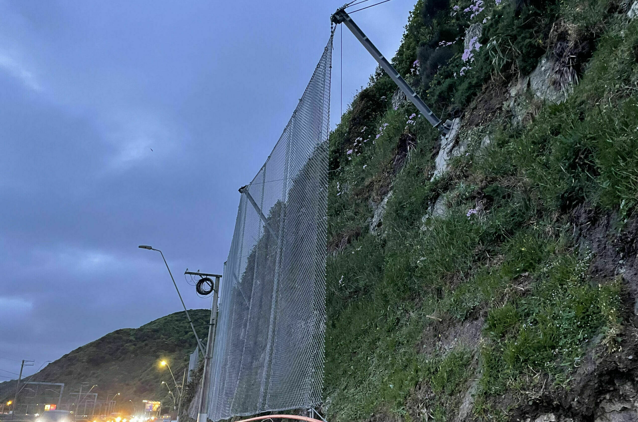 Rockfall protection barrier fence installed on a rockface alongside a New Zealand highway
