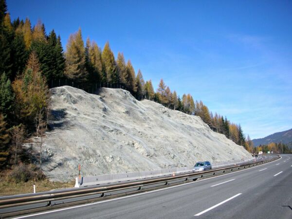Geoquest Australia – Specialists in Geohazard and Slope Stabilisation slope stabilisation net installed on a slope next to a highway