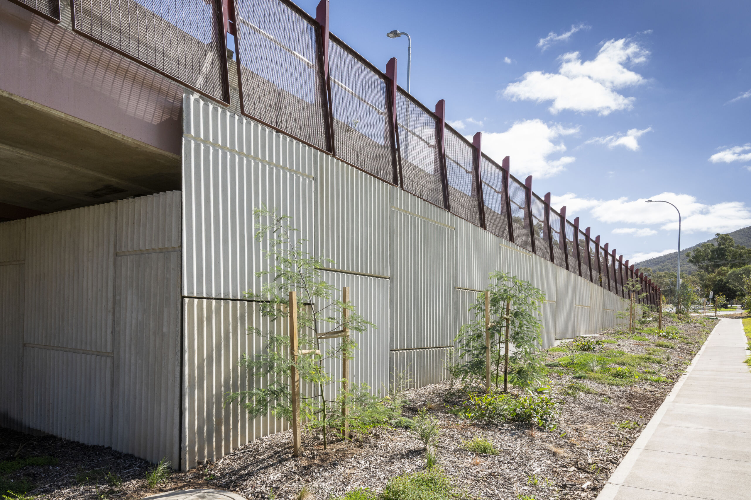 A reinforced earth wall (MSE wall) at the Sydney Gateway project, New South Wales, which has pre cast concrete facing panels with decorative elements engraved.